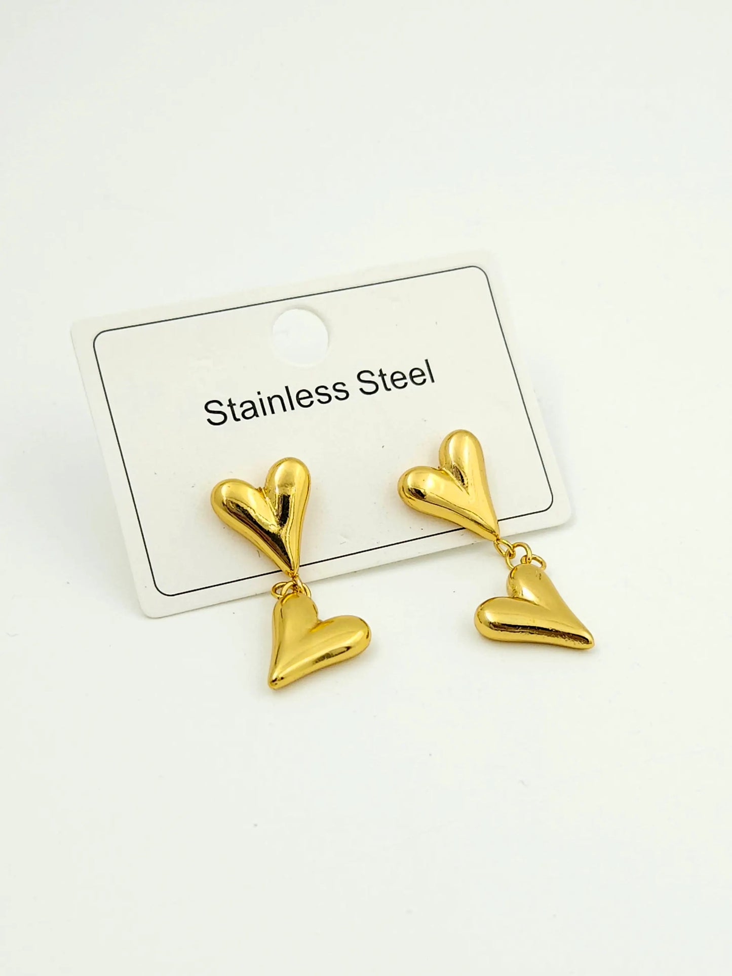 Gold heart-shaped earrings on a white card with 'Stainless Steel' text.