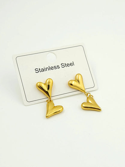 Gold heart-shaped earrings on a white card with 'Stainless Steel' text.
