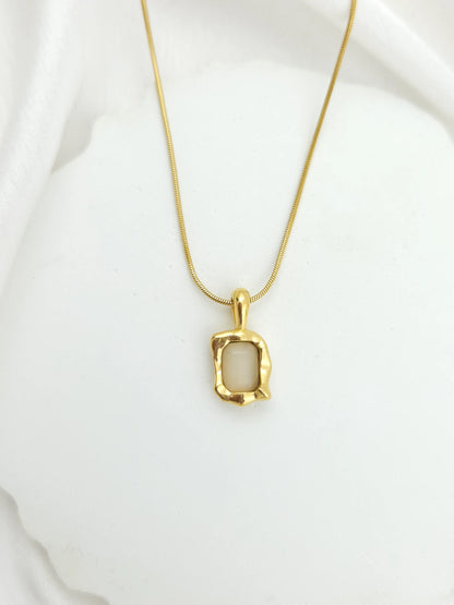 Gold necklace with a pendant on a white background