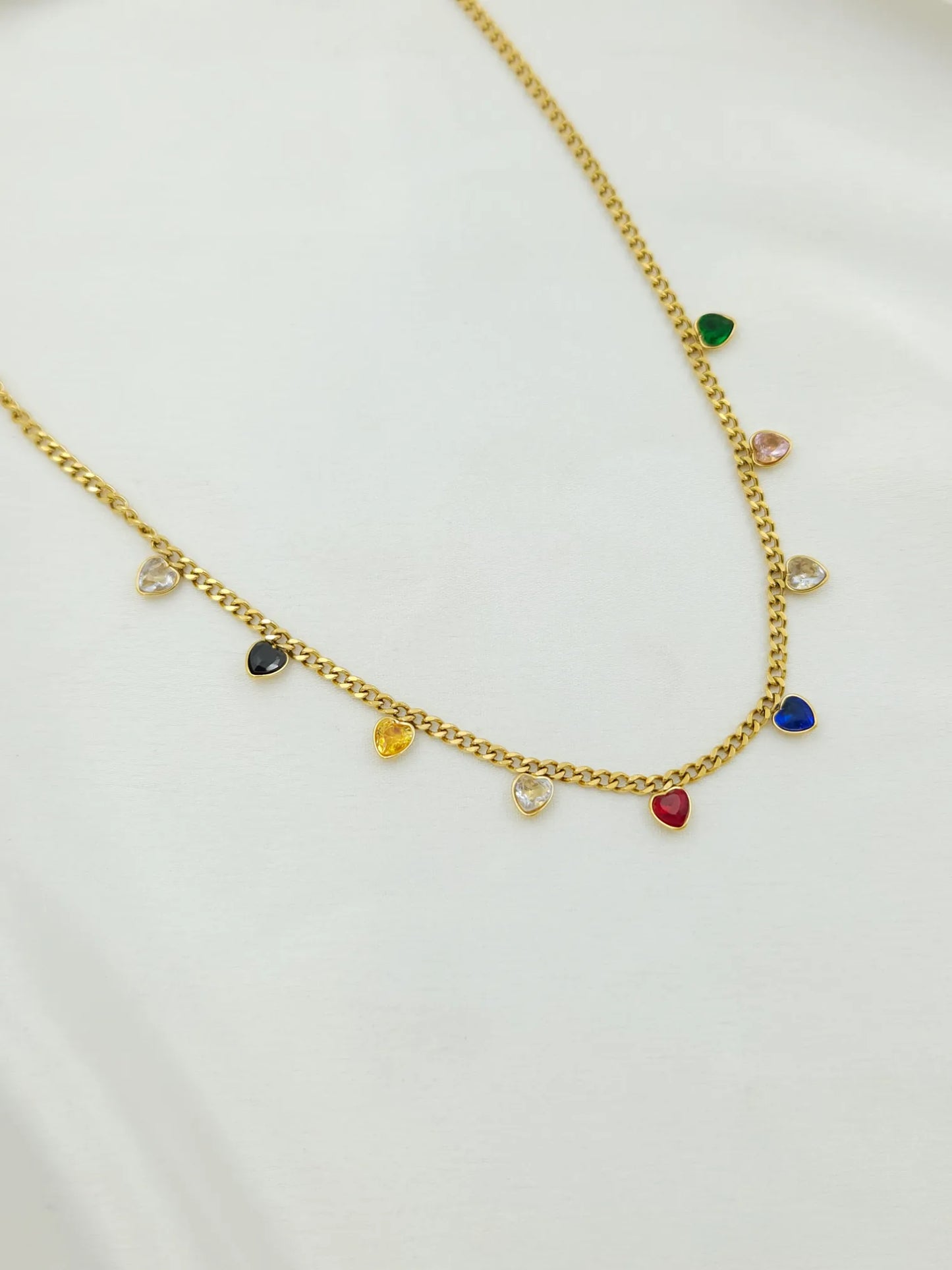 Gold necklace with colorful charms on a white background